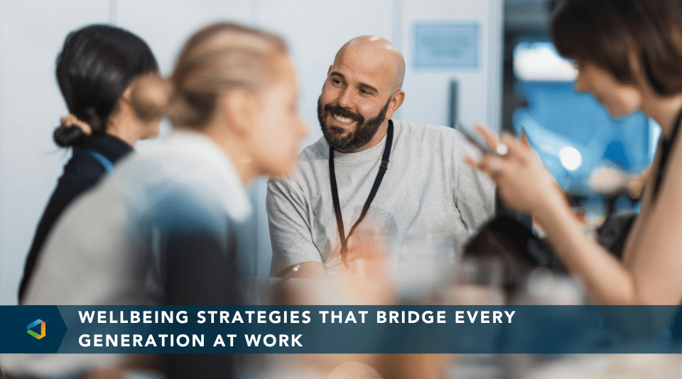 Group of diverse employees from multiple generations collaborating in a modern office, symbolizing workplace wellbeing and inclusion.